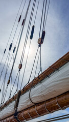 Sail rigging is in view with ropes and pulleys against the sky © Creative house