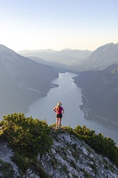 Young woman looking over mountain landscape, view from the mountain B&auml;renkopf to Lake Achensee, Tyrol, Austria