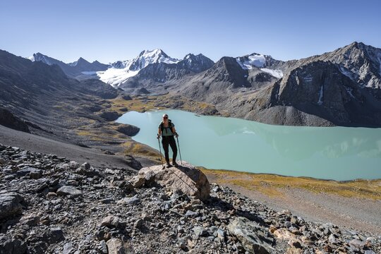 Trekking, hiker in the Tien Shan high mountains, mountain lake Ala-Kul Lake, 4000 metre peak with glacier, Ak-Su, Kyrgyzstan