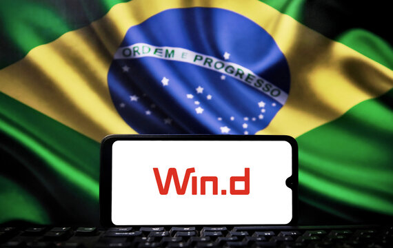 A smartphone displaying the Wind Financial Terminal logo over a computer keyboard, with the flag of Brazil in the background, illustrating the financial integration and B3 market data partnership.