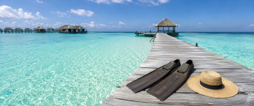 Relaxing view of tropical pier with flippers and hat