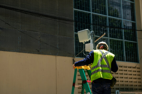 Worker Installing Equipment in Urban Area