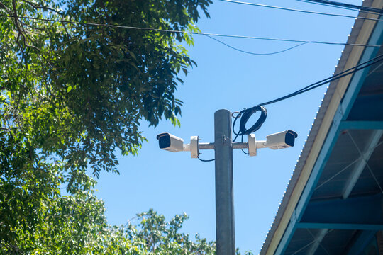 Utility Pole with Cameras and Wires Under Blue Sky