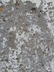 Fototapeta premium Rough Concrete Wall Texture with Peeling White Paint and Pebbles Grunge Background 