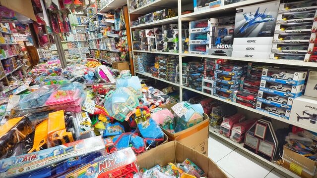 A cluttered toy store aisle filled with various toys and merchandise.