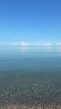 Minimalist view of calm Black Sea clear water and pebble beach in Georgia