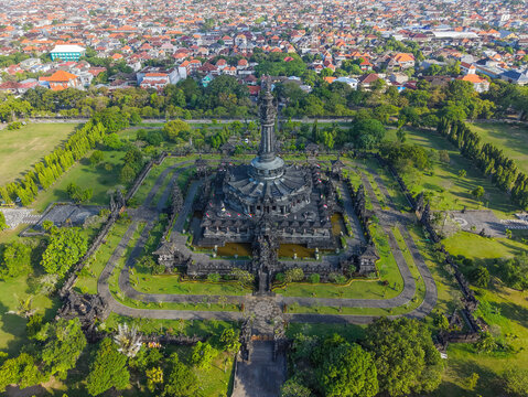 Warm morning light rakes across the dark stone tiers and carved reliefs of Bajra Sandhi, casting long shadows across the surrounding lawns and highlighting the monument's sculptural detail.