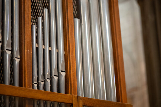  Close-Up Detail of Silver Metal Pipe Organ Pipes in Wooden Frame, Church Interior - A tight macro-style shot of a series of polished silver metal organ pipes housed within a warm wooden frame.