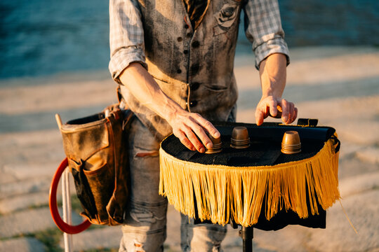 Street Performer Shows a Magic Trick Near the River in Evening Light