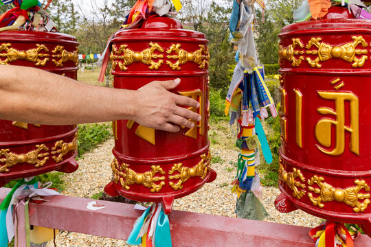 A hand spins a Buddhist prayer wheel.