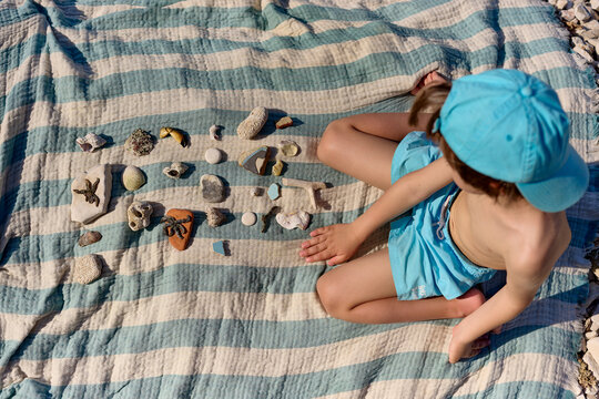 Child playing with seashells on the beach