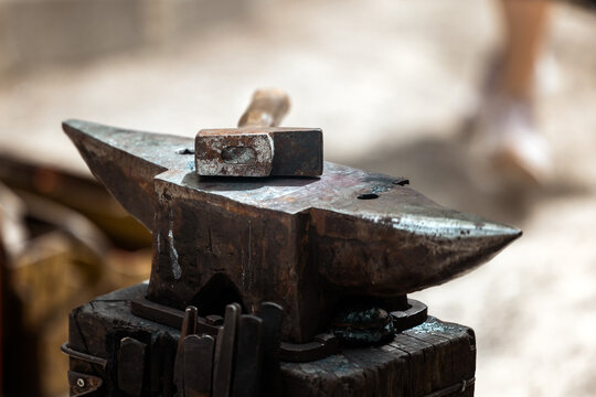 Rusty Hammer Resting on Aged Blacksmith Anvil