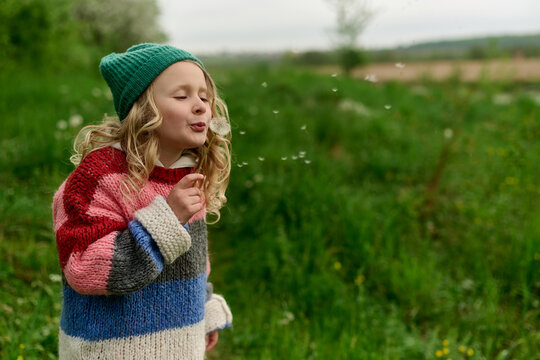 Girl Blowing Dandelion Seeds