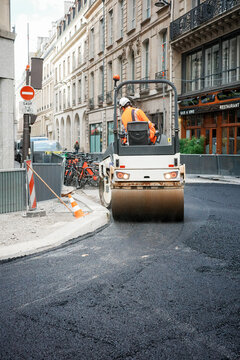 Road roller compacting fresh asphalt on Paris street