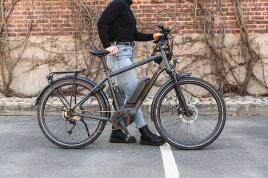 Detail shot of woman standing with modern grey electric bike