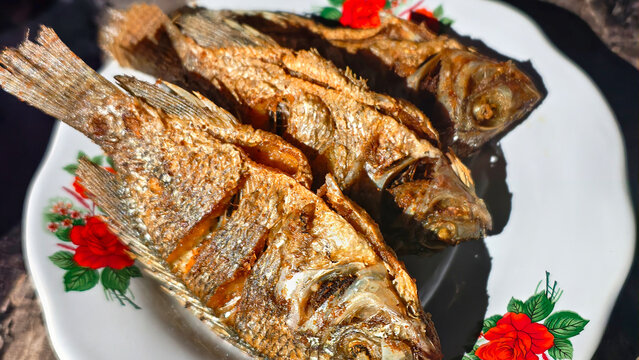 Crispy Fried Fish Dish Served on a White Plate with Floral Design.