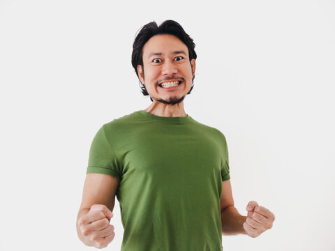 Excited energetic Asian man in green t-shirt with active pose isolated on white.
