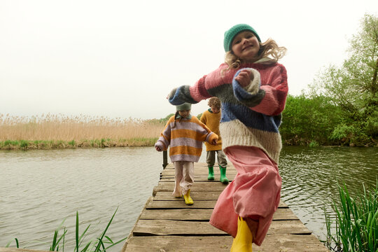 Children Running on Lakeside Dock