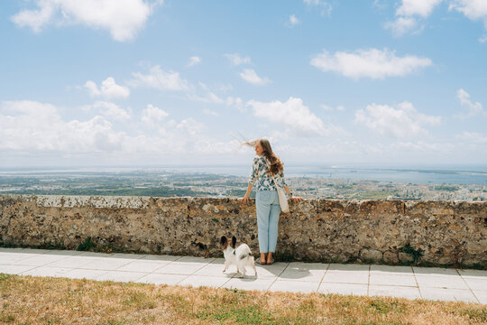 Woman and small dog enjoying panoramic city view from historic s