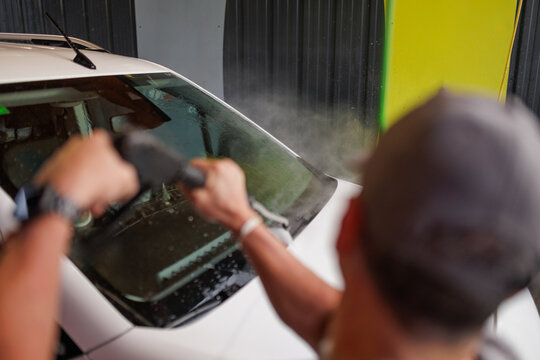 A man washing his car at a self-service car wash