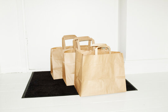 Delivery from courier of brown takeaway packages boxes in hallway