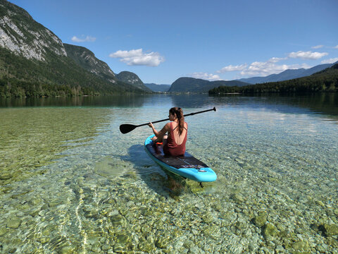 A woman on a paddleboad floating on a lake.