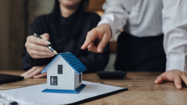 Businessman, house and condo sales representative Hand over the keys to the customer and sign the sales or rental contract according to mutual agreement in the office. Real estate business concept