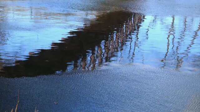 Reflection of an iron bridge in the flowing waters of the Delaware and Raritan Canal within a state park in New Jersey, USA.