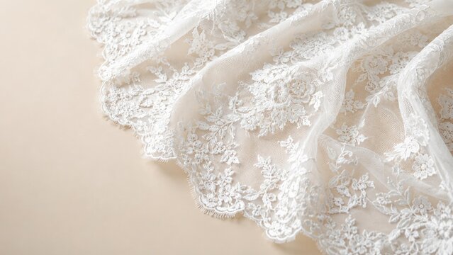 Delicate ivory lace with scalloped embroidered edge draped over a neutral background, bridal fabric detail for wedding veils and gown hems