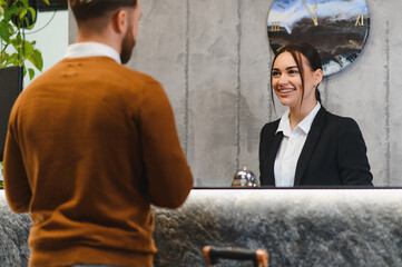 Fototapeta na wymiar Hotel receptionist assisting guest with check in service