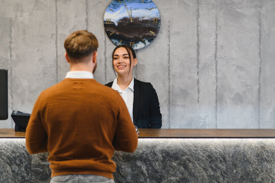Hotel receptionist assisting guest with check in service