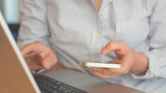 Professional using Smartphone, Laptop Simultaneously for Business Communication, Digital workflow, Mobile Productivity.Modern Remote Work featuring Multitasking, Online Collaboration, Task management 