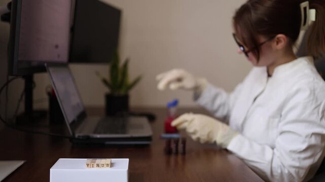Scientist tracks virus test results on computer while handling laboratory samples Research focused on outbreak monitoring infection detection and public health