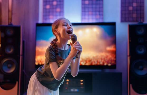 Joyful Young Girl Singing Karaoke at Home with Microphone