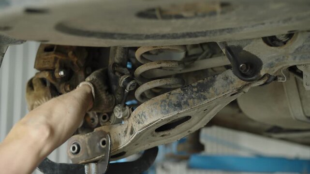 Car rear suspension repair with coil spring and control arm in auto service