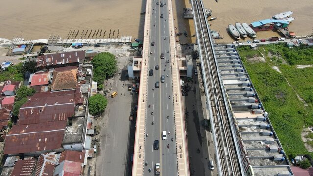Aerial view of Jembatan Ampera with traffic on the bridge and boats on the Musi River in Kecamatan Seberang Ulu I, Sumatera Selatan, Indonesia.