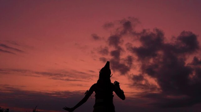 Late sequence shows musician near center-left in dark silhouette, holding saxophone against vivid pink, orange, and purple dusk clouds with calm backlit mood