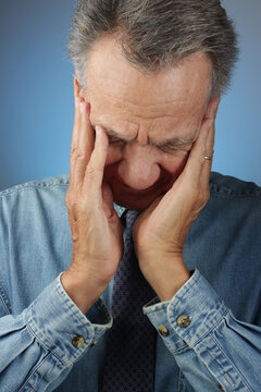 Older Senior Man holding his head down in his hands
