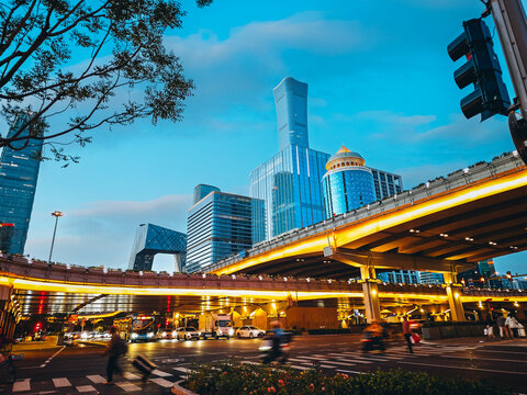 Scenic low angle view of the China Zun CITIC Tower and CBD skyscrapers behind a multilevel overpass illuminated by golden sunset light at Guomao Bridge, Chaoyang, Beijing, China
