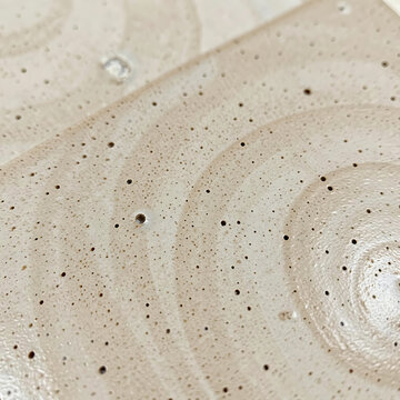 Mocha colored ceramic slab with speckled texture and subtle wave patterns