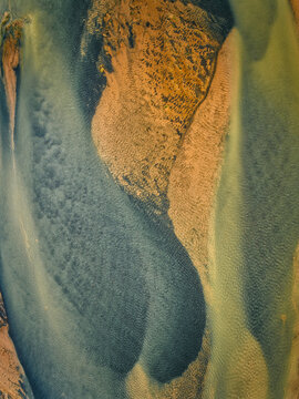 Aerial view of the river delta near Selfoss, showcasing intricate patterns of sandbars, shallow turquoise water, and deep blue channels, Selfoss, Sveitarfelagid Arborg, Iceland.