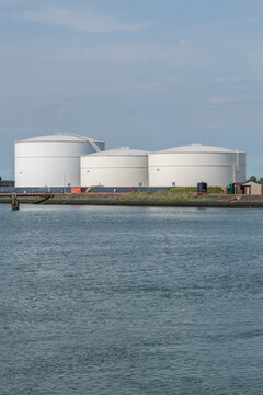 Vlissingen, Netherlands. Coastal fuel storage tanks for petroleum and biofuels with water foreground at industrial port