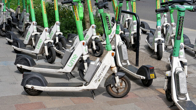 Manchester, England, UK - 18 June 2026: Lime electric scooters, e-scooter sharing service parked on city sidewalk pavement street public transport vehicle fleet