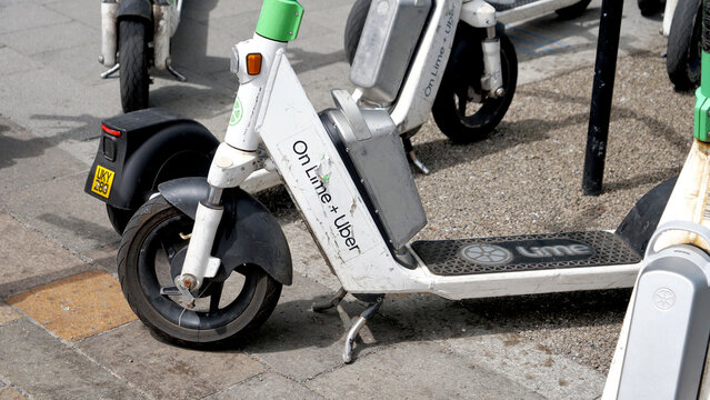 Manchester, England, UK - 18 June 2026: Lime and Uber electric scooter close up, partnership e-scooter sharing service vehicle parked on city street sidewalk
