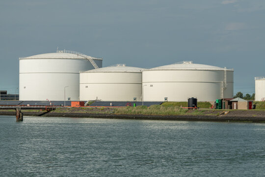 Vlissingen, Netherlands. Large oil and biofuel storage tanks at coastal industrial site with water foreground and energy infrastructure