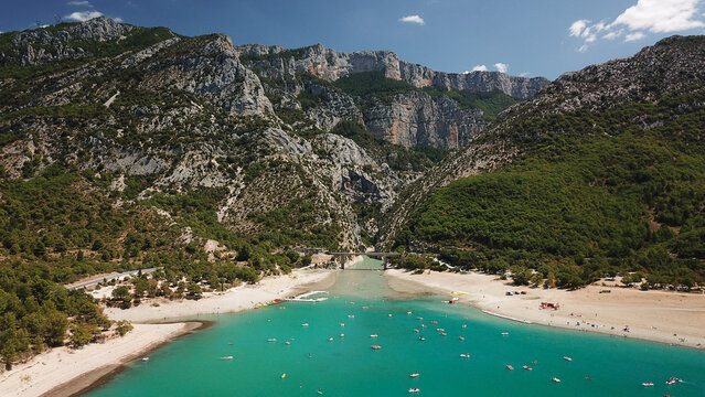Aerial view of Lake of Sainte-Croix with turquoise water, sandy beaches, and surrounding limestone cliffs in Provence-Alpes-Cote d'Azur, France.