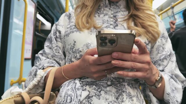 Stylish Woman Scrolling Phone on Subway Ride in Milan