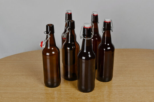 Grupo de botellas de cervezas artesanal con cierre herm&eacute;tico sobre mesa de madera