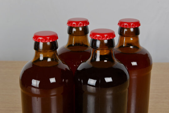 Grupo de botellas de cervezas artesanal con chapa roja sobre mesa de madera