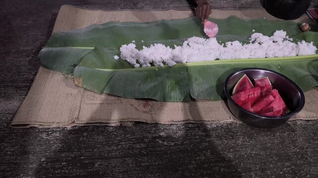 Traditional communal rice meal served elegantly atop fresh banana leaves during festive family gatherings.